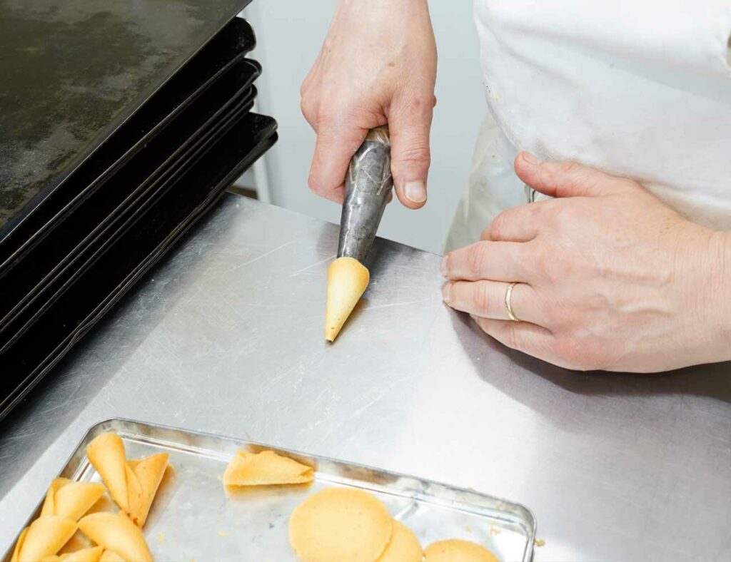 Mains d’artisan travaillant des produits de pâtisserie